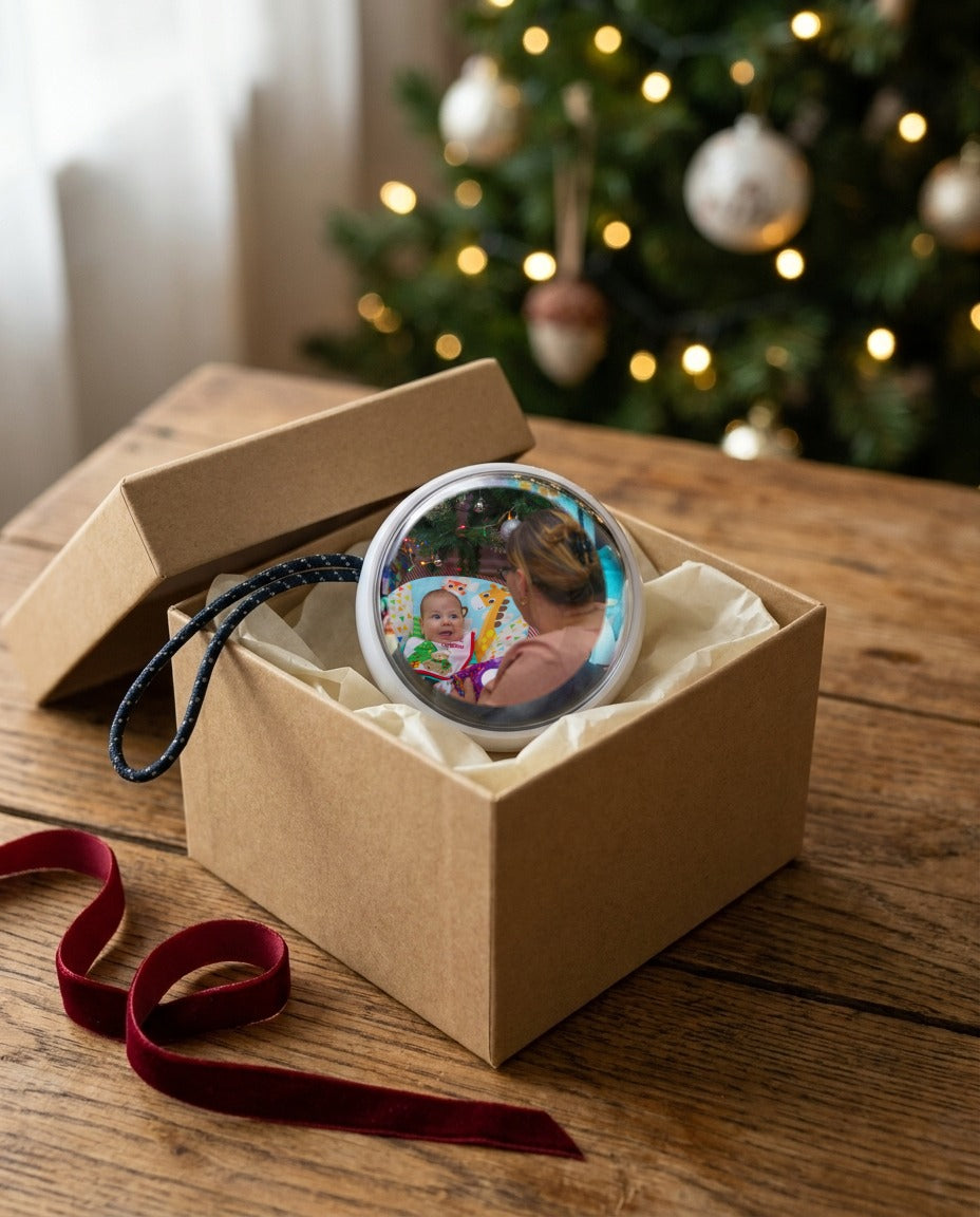A Glowkeep memory orb in its gift box, a baby's first-Christmas photo on the screen